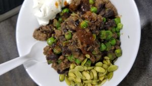 Cumin beef taco meat with black beans frozen peas pepitas and sour cream