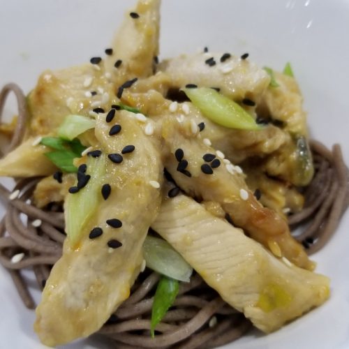 Ginger chicken stir fry using sugar free apricot preserves garnished with sesame seeds and scallions served over a bed of buckwheat soba noodles