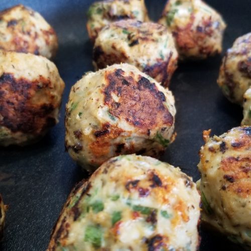 Sundried tomato turkey meatballs with feta cheese, garlic, basil, oregano and arugula cooked on a skillet