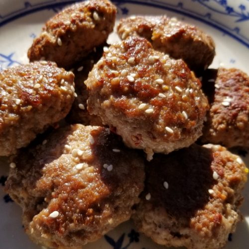 Pork patties seasoned with chinese 5-spice and garnished with sesame seeds