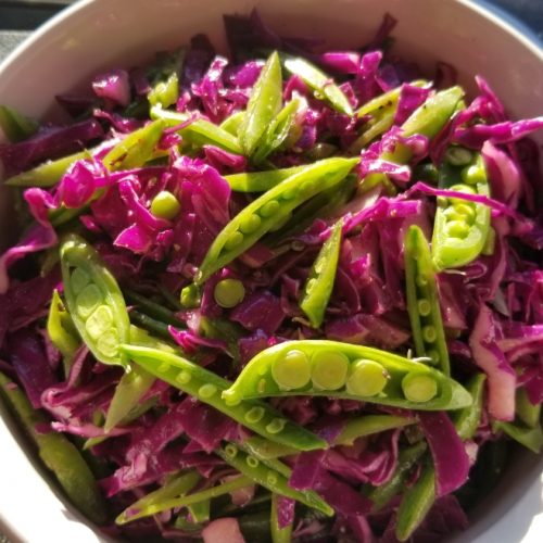 Purple cabbage slaw with snap peas green onions, lime juice, cumin, and coriander